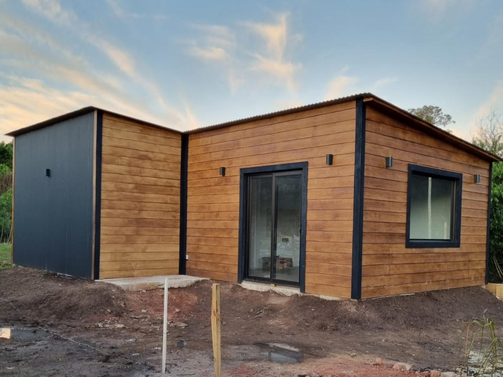 Diseño de vivienda funcional, fusionando madera y chapa prepintada en color negro aportando modernidad y mayor duración en el tiempo